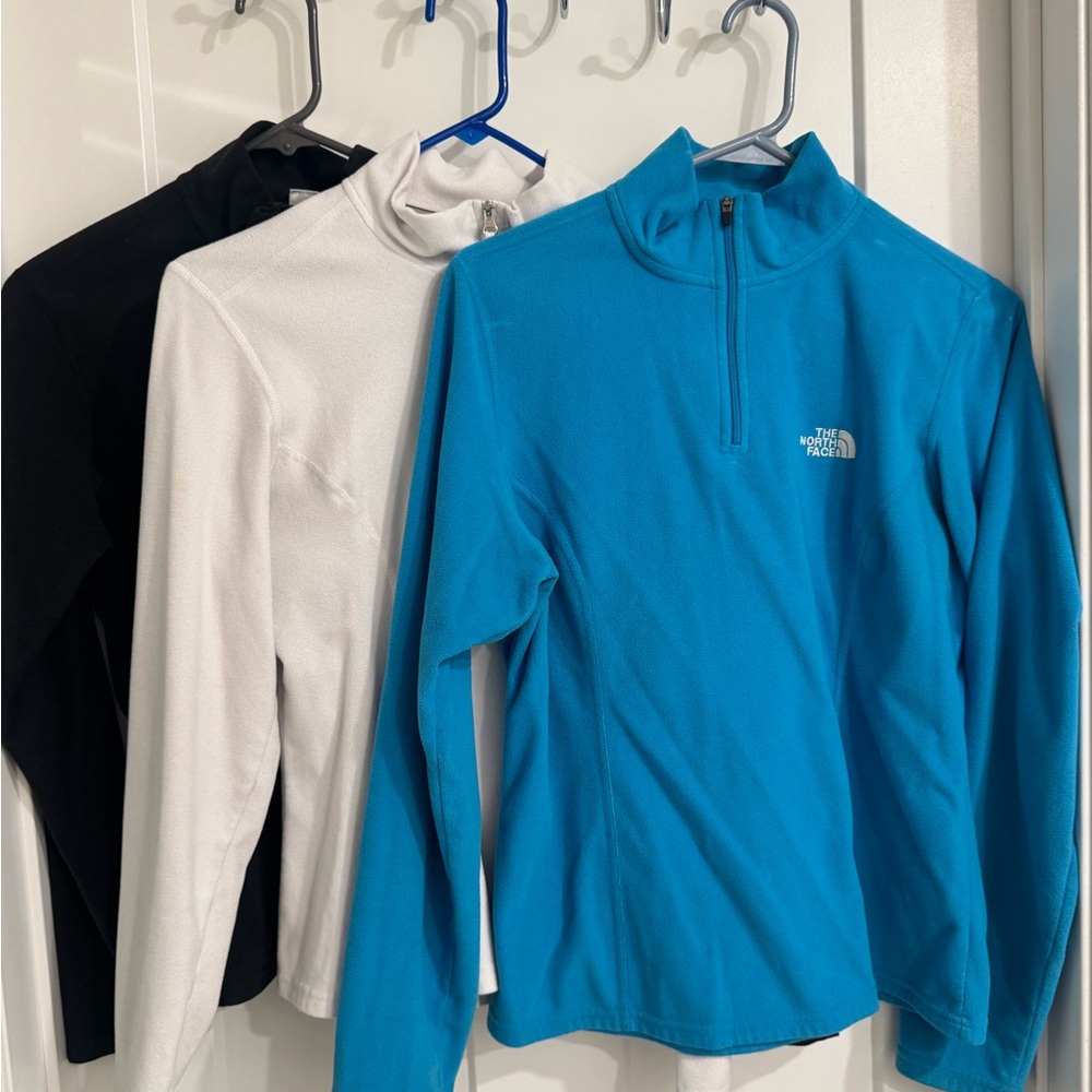 The North Face Trio: Black, White, and Blue Pullovers